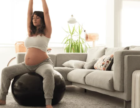 Femme enceinte qui s'étire assise sur un ballon